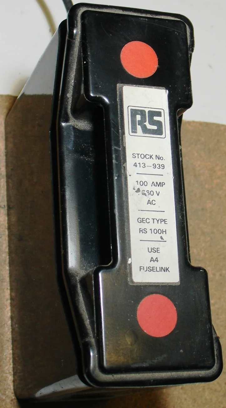 Closed industrial fuse holder beside a 100 ampere cartridge fuse; representative family image, not a Mersen BBB32F1 photograph.